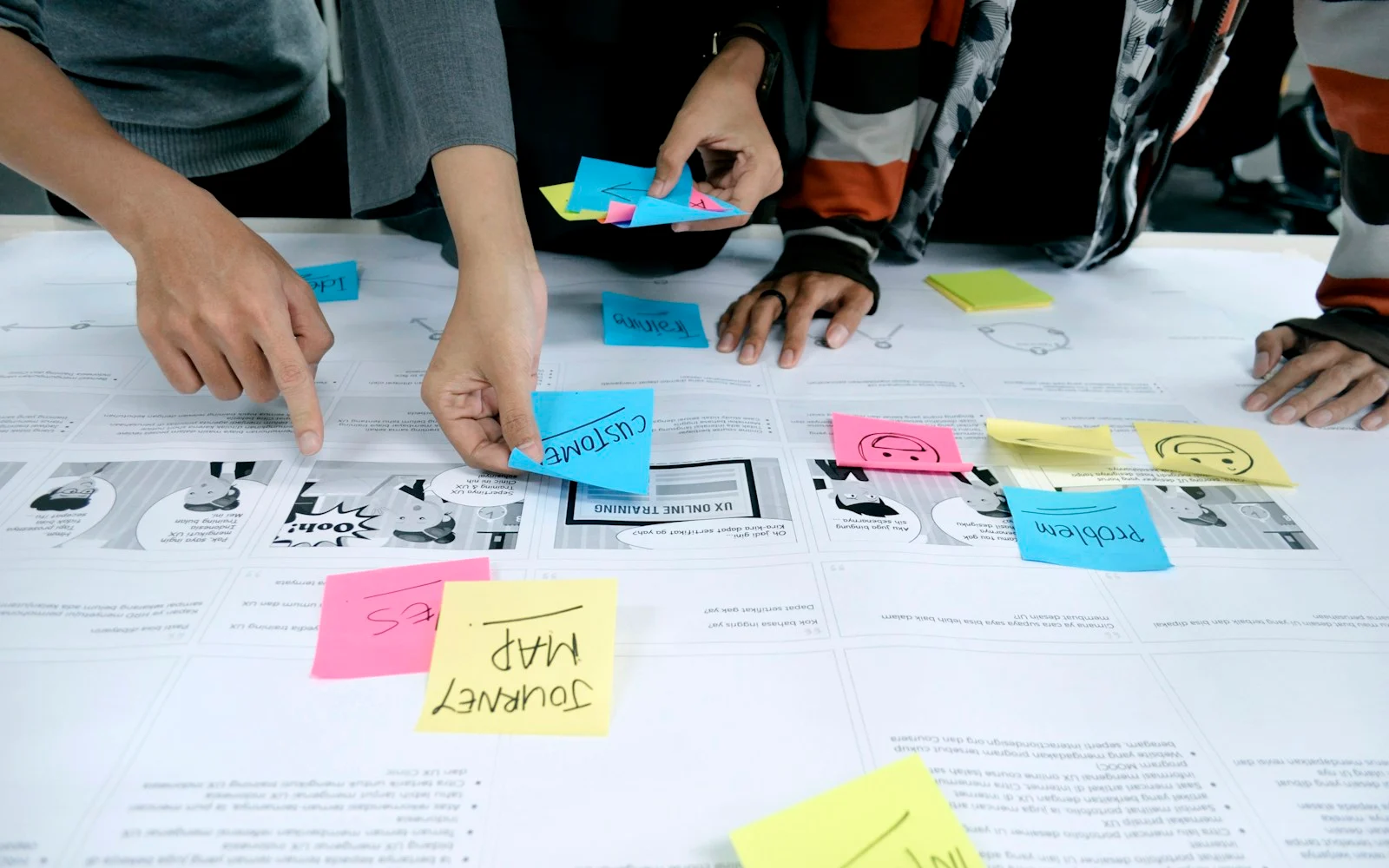 Equipe organizando ideias com post-its sobre uma mesa